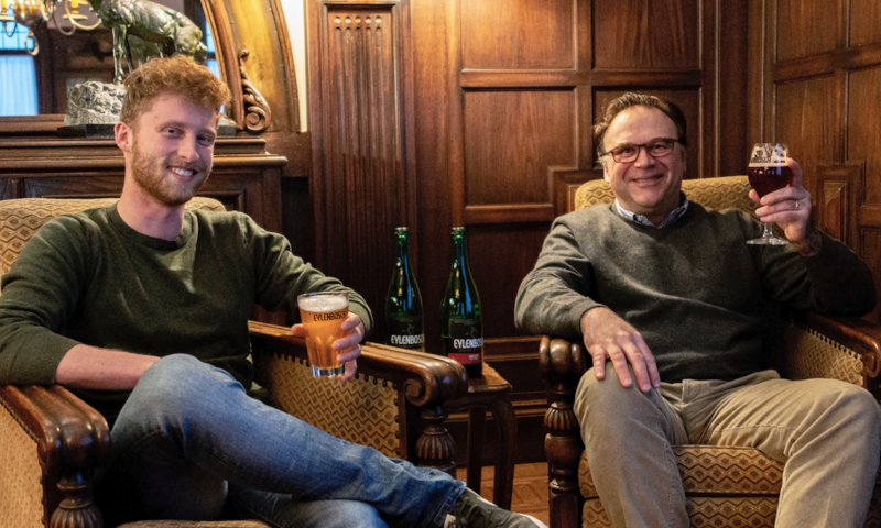 Twee oprichters van Brouwerij Eylenbosch zittend in een fauteuil met een glas bier in de hand